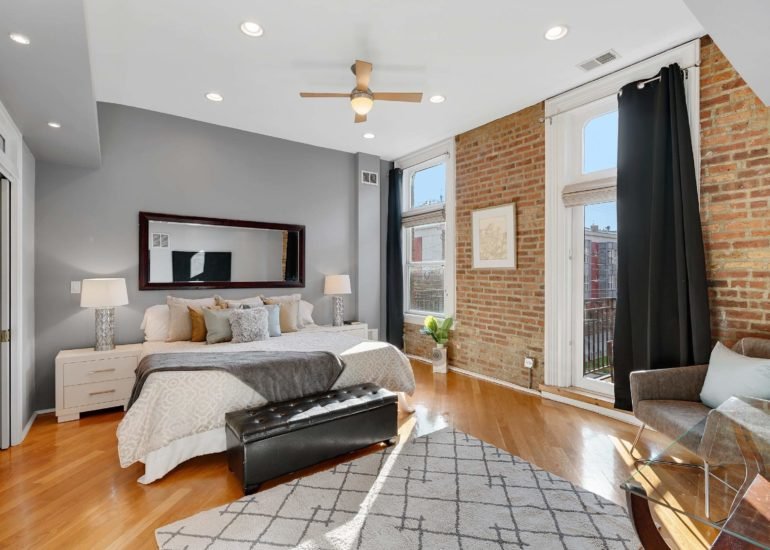 Beautiful master bedroom (primary bedroom) real estate photo, with the exposed brick wall